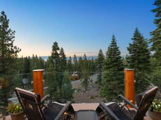 Enjoy breathtaking views from this stunning property, featuring a spacious balcony with comfortable lounge chairs perfect for relaxation.