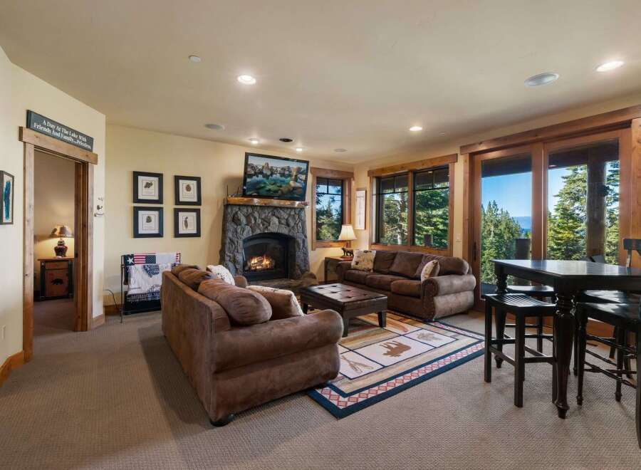 Experience ultimate relaxation in this cozy living room, featuring a grand stone fireplace and comfortable seating.