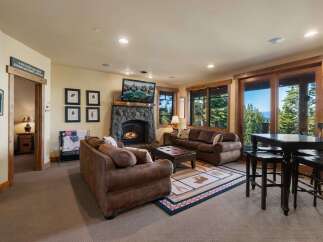 Experience ultimate relaxation in this cozy living room, featuring a grand stone fireplace and comfortable seating.