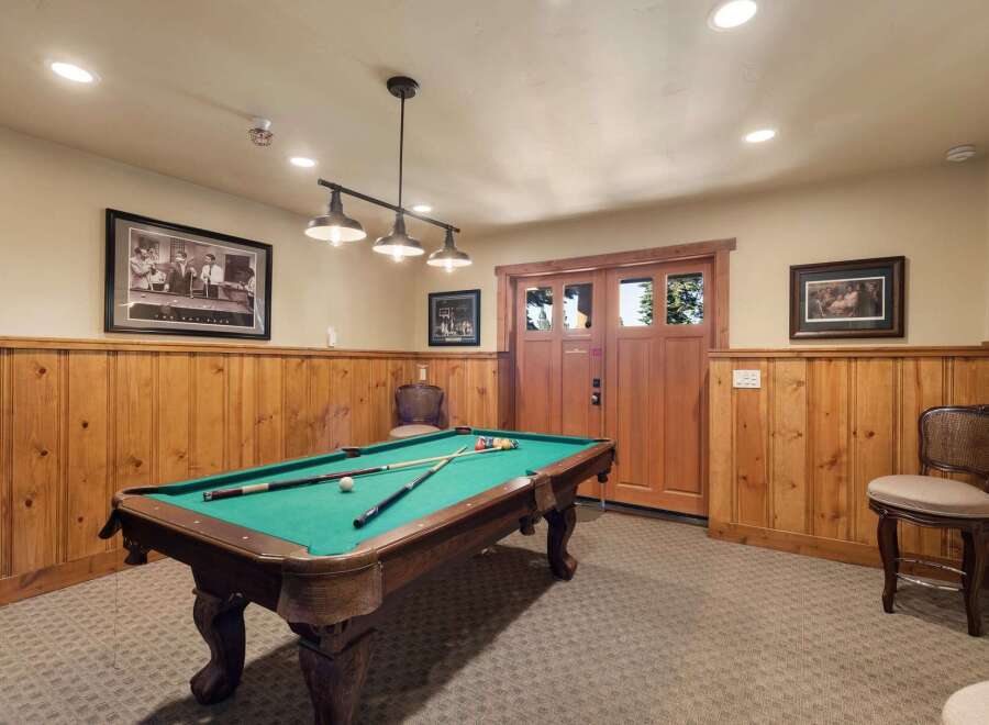 Enjoy endless entertainment in this game room, featuring a classic pool table perfect for friendly competitions.
