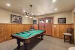 Enjoy endless entertainment in this game room, featuring a classic pool table perfect for friendly competitions.