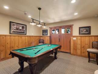 Enjoy endless entertainment in this game room, featuring a classic pool table perfect for friendly competitions.