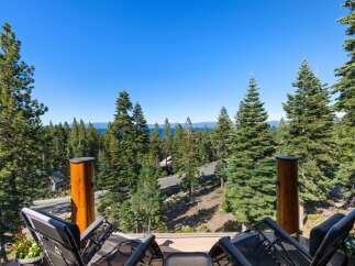 Enjoy breathtaking lake and mountain views from this stunning property, nestled amidst towering pine trees.