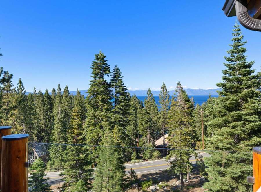 Experience breathtaking lake and mountain views from this stunning property, nestled amidst a lush forest of towering pine trees.