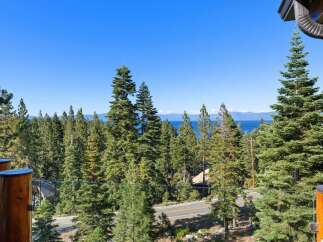 Experience breathtaking lake and mountain views from this stunning property, nestled amidst a lush forest of towering pine trees.