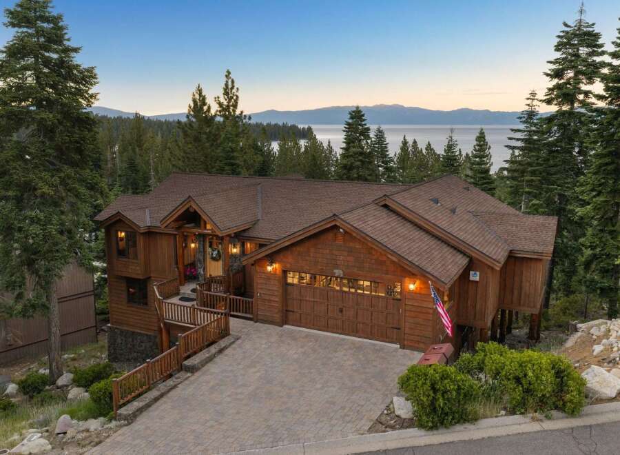 Experience luxurious mountain living in this stunning wooden home, nestled amidst towering pine trees with breathtaking lake and mountain views.
