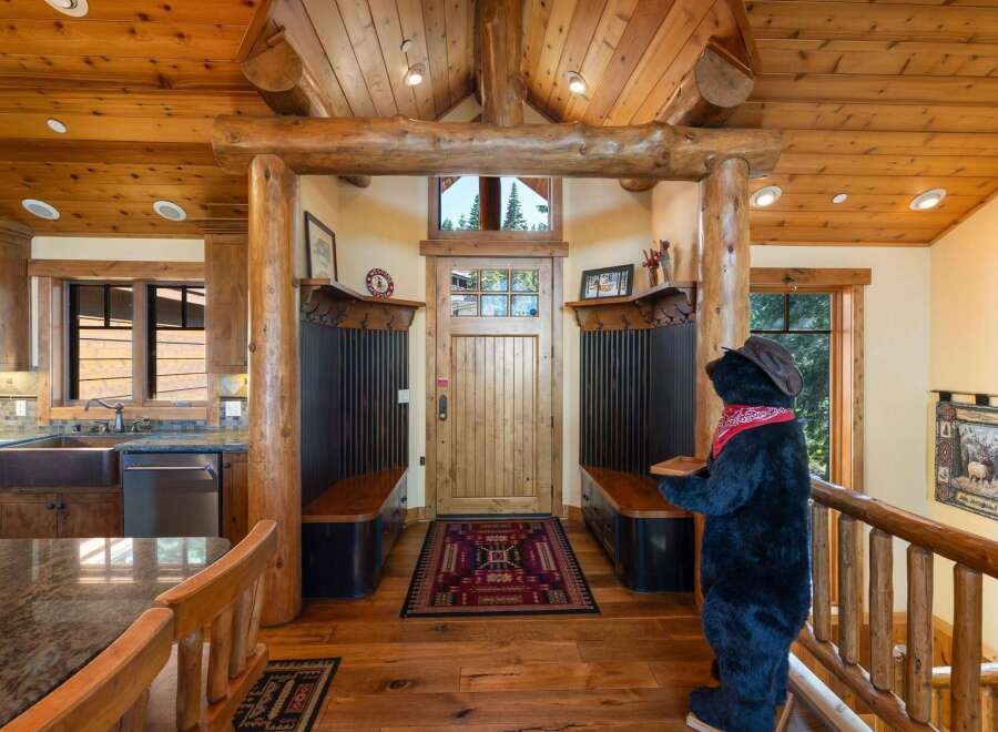 Step into a warm and inviting entryway featuring rustic log accents and a charming wooden door.