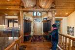 Step into a warm and inviting entryway featuring rustic log accents and a charming wooden door.