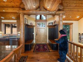Step into a warm and inviting entryway featuring rustic log accents and a charming wooden door.