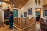 Experience rustic charm in this mountain lodge-inspired entryway, featuring a life-sized bear statue and a cozy log railing.
