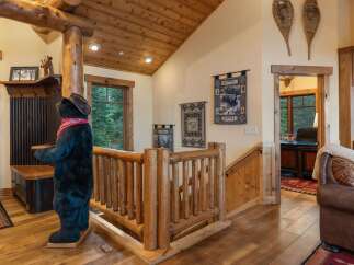 Experience rustic charm in this mountain lodge-inspired entryway, featuring a life-sized bear statue and a cozy log railing.