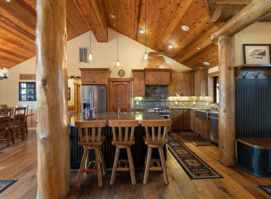 Experience rustic charm in this spacious kitchen featuring a large island with bar seating, perfect for casual dining and entertaining.