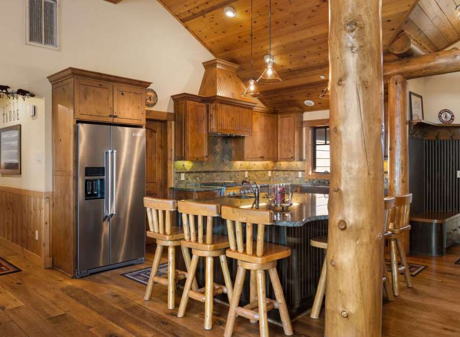 Experience rustic charm in this spacious kitchen featuring warm wood cabinetry and a large granite island perfect for entertaining.