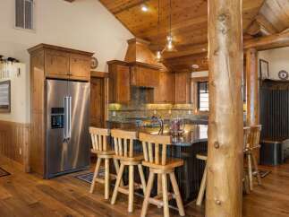 Experience rustic charm in this spacious kitchen featuring warm wood cabinetry and a large granite island perfect for entertaining.