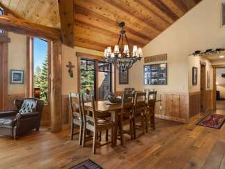 Experience rustic charm in this spacious dining room, featuring a large wooden table perfect for family gatherings.