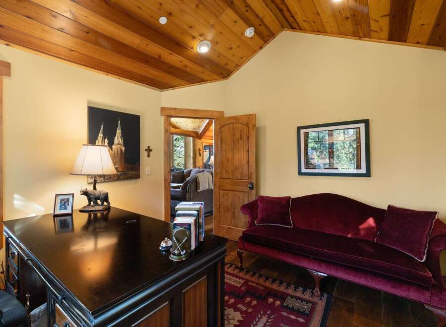 This charming office space features a rich wooden ceiling and walls painted in a warm, inviting yellow.