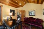 This charming office space features a rich wooden ceiling and walls painted in a warm, inviting yellow.