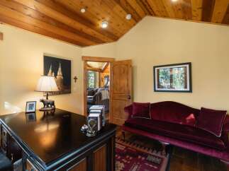 This charming office space features a rich wooden ceiling and walls painted in a warm, inviting yellow.