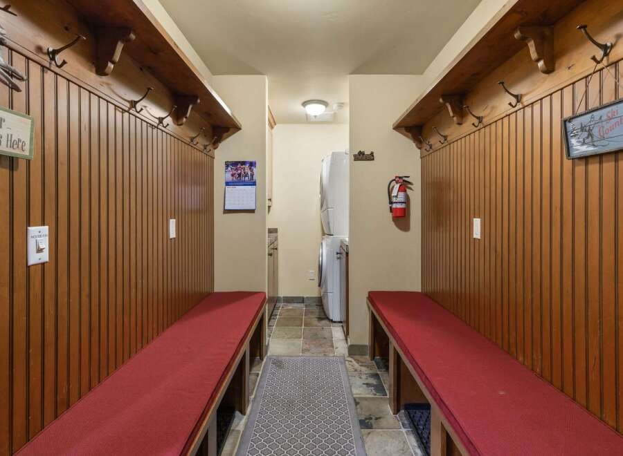 This charming mudroom features rustic wooden paneling and ample coat hooks, perfect for storing outdoor gear.