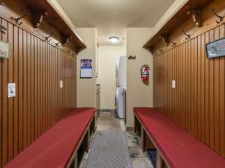 This charming mudroom features rustic wooden paneling and ample coat hooks, perfect for storing outdoor gear.