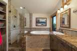 Experience luxury in this stunning bathroom featuring a spacious walk-in shower with elegant tilework and a deep soaking tub perfect for relaxation.