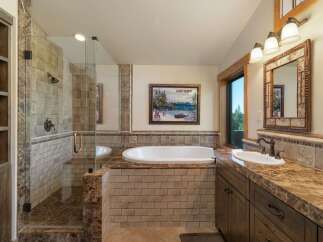 Experience luxury in this stunning bathroom featuring a spacious walk-in shower with elegant tilework and a deep soaking tub perfect for relaxation.