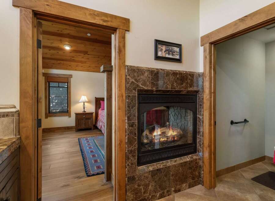 Cozy up by the gas fireplace, featuring a rich marble surround and a rustic wood mantel.