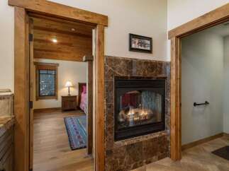 Cozy up by the gas fireplace, featuring a rich marble surround and a rustic wood mantel.