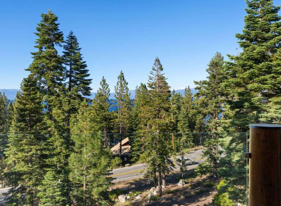 Experience breathtaking lake views and serene mountain vistas from this stunning property, nestled amidst towering pine trees.