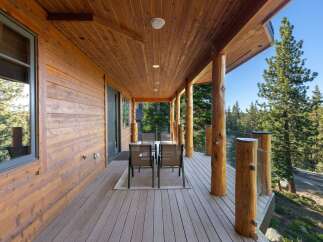 Experience the perfect blend of rustic charm and modern comfort on this expansive covered deck, ideal for enjoying the serene mountain views.