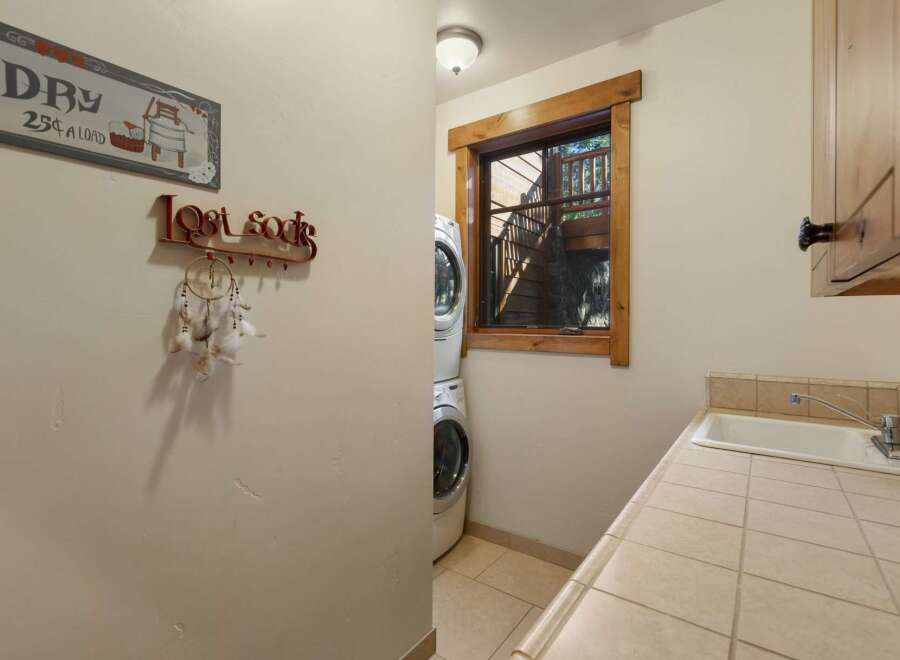 This charming laundry room features a stacked washer and dryer, perfect for maximizing space.