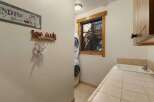 This charming laundry room features a stacked washer and dryer, perfect for maximizing space.