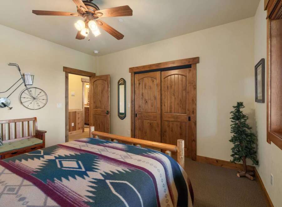 Experience rustic charm in this inviting bedroom, featuring a cozy bed adorned with a Native American-inspired blanket.