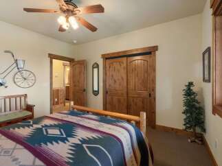 Experience rustic charm in this inviting bedroom, featuring a cozy bed adorned with a Native American-inspired blanket.