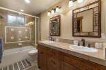 This charming bathroom features a spacious bathtub with a glass enclosure and decorative tile accents.