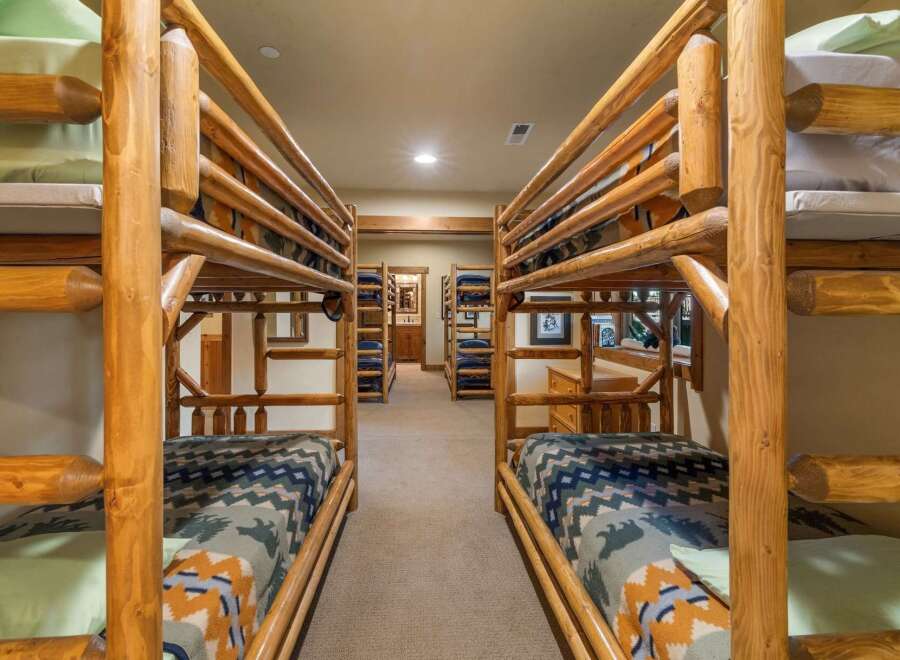This rustic bedroom features multiple log bunk beds, perfect for accommodating large families or groups.