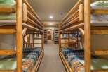 This rustic bedroom features multiple log bunk beds, perfect for accommodating large families or groups.