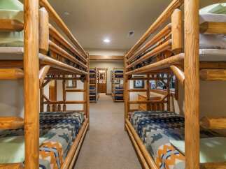 This rustic bedroom features multiple log bunk beds, perfect for accommodating large families or groups.