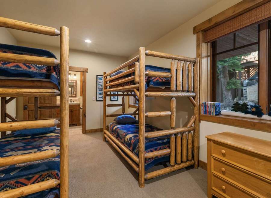 This charming bedroom features rustic log bunk beds, perfect for accommodating family and friends.