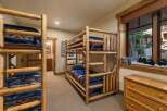 This charming bedroom features rustic log bunk beds, perfect for accommodating family and friends.