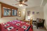Experience rustic charm in this cozy bedroom, featuring a comfortable log bed adorned with a charming bear-themed quilt.