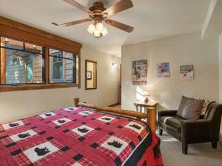 Experience rustic charm in this cozy bedroom, featuring a comfortable log bed adorned with a charming bear-themed quilt.