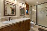 This rustic bathroom features a double vanity with unique twig-framed mirrors and oil-rubbed bronze fixtures.