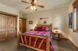 Experience rustic charm in this cozy bedroom, featuring a beautiful log bed adorned with bear-themed linens and pillows.