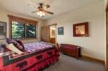 Experience rustic charm in this cozy bedroom featuring a comfortable bed with a bear-themed quilt and plush pillows.