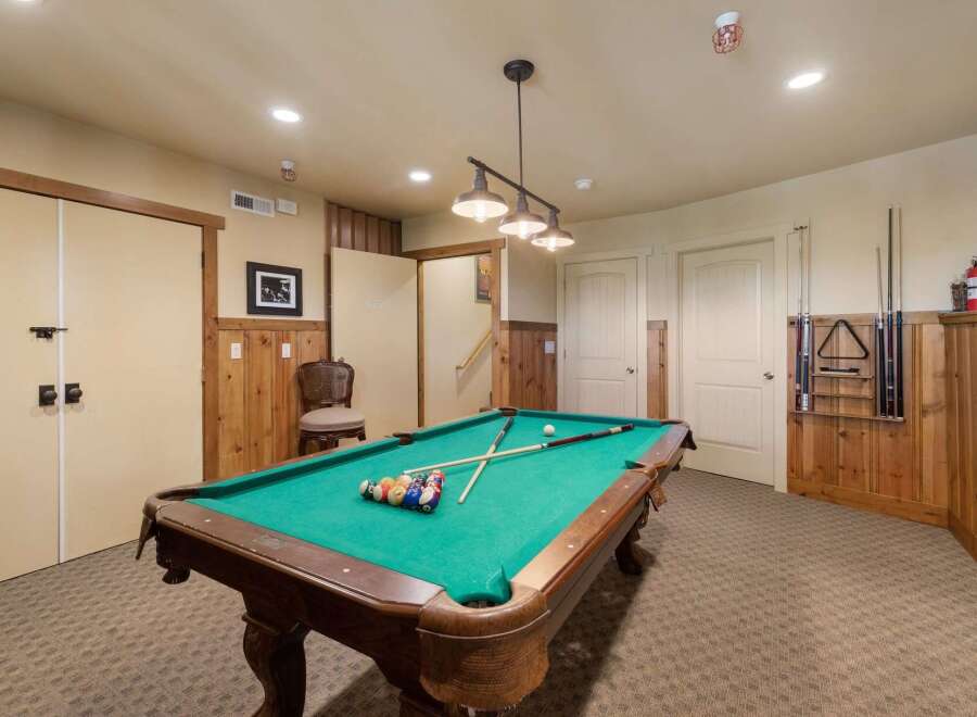 Enjoy endless entertainment in this home's dedicated game room, featuring a classic pool table perfect for friendly competitions.