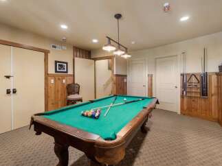 Enjoy endless entertainment in this home's dedicated game room, featuring a classic pool table perfect for friendly competitions.