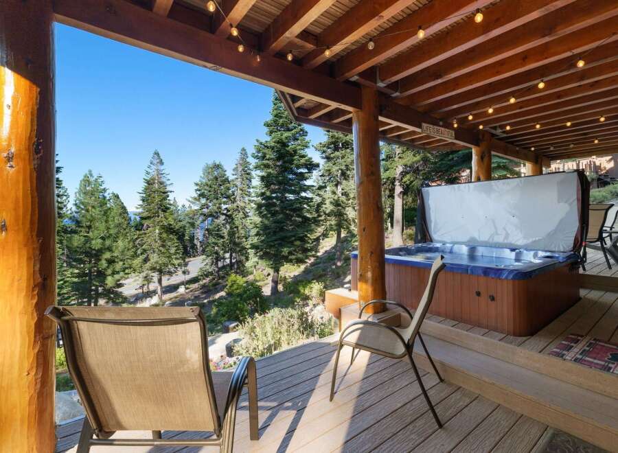 Experience ultimate relaxation on this stunning deck, featuring a luxurious hot tub with breathtaking forest and lake views.