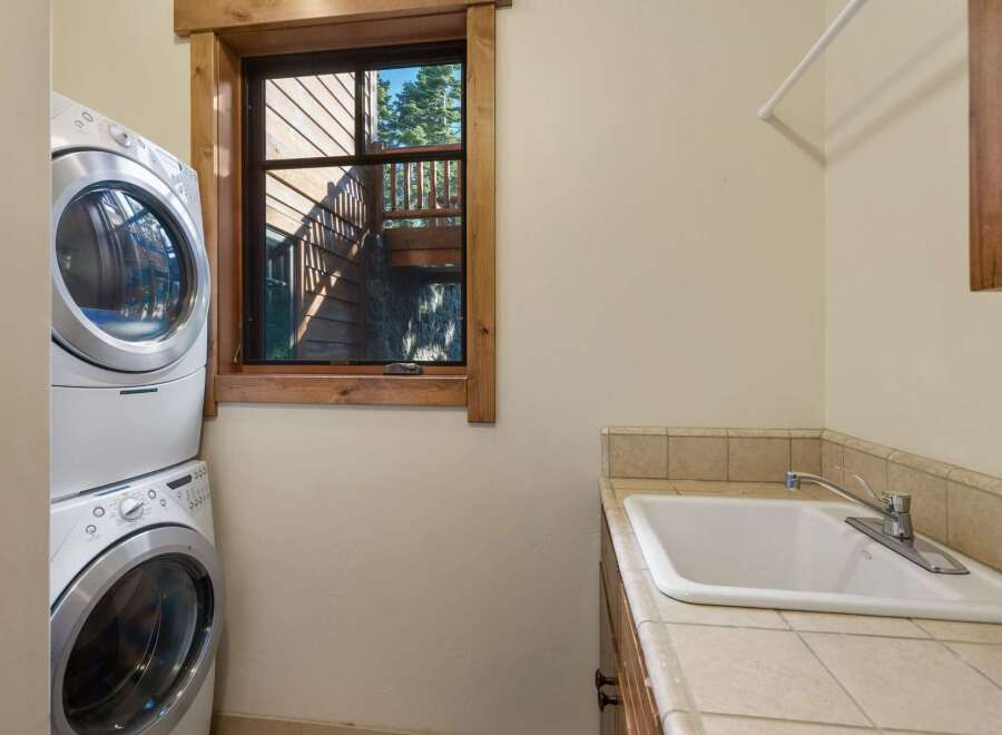 This laundry room features a stacked washer and dryer for space efficiency.
