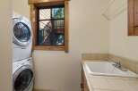 This laundry room features a stacked washer and dryer for space efficiency.